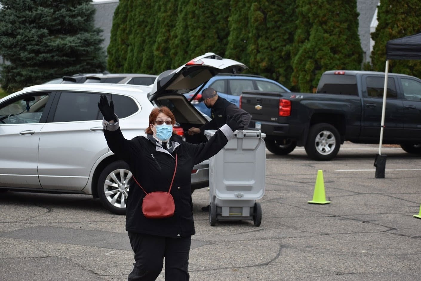 Masked volunteer directing cars at Shred Right drive-through event