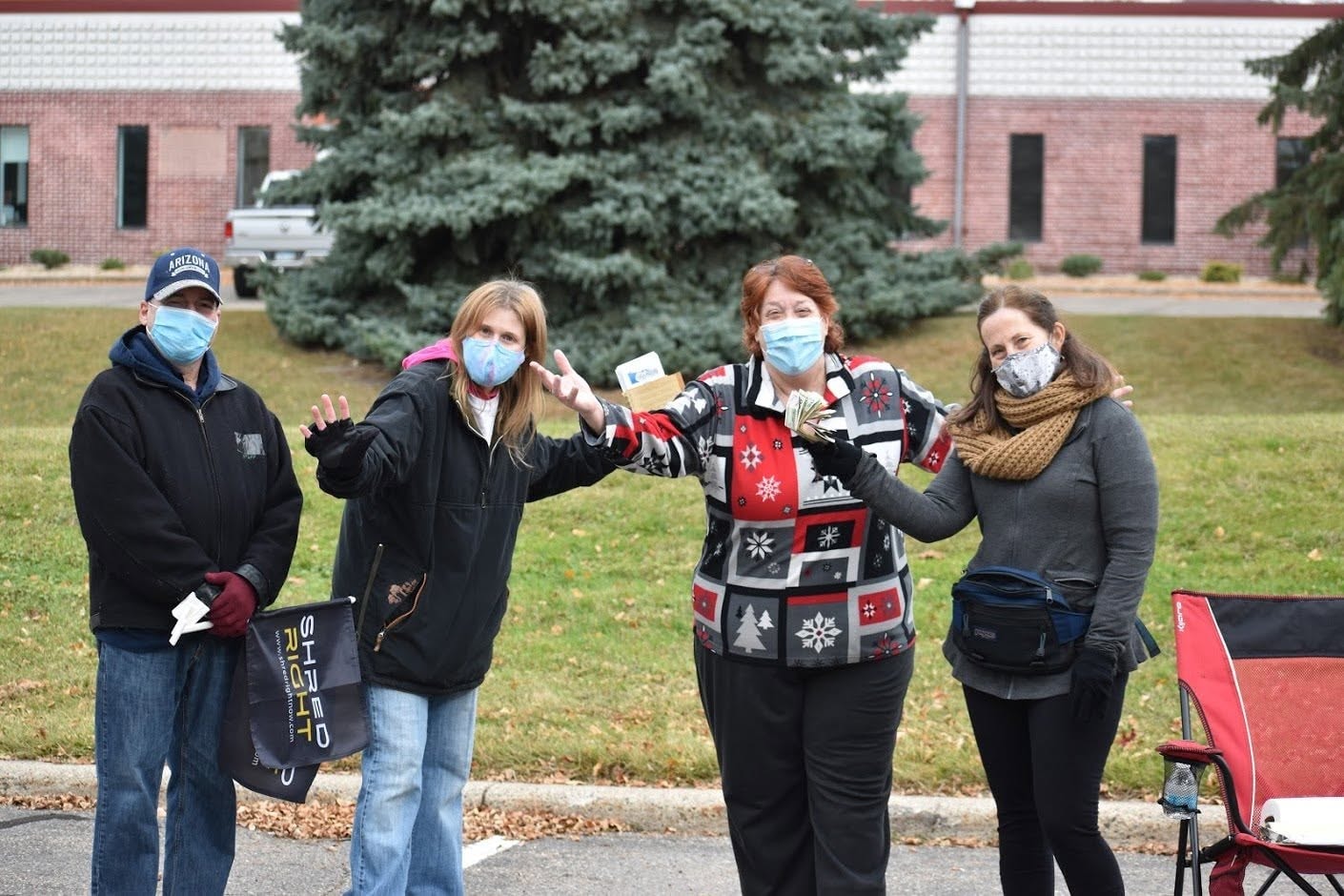 Four masked MNHTF volunteers celebrating at Shred Right event